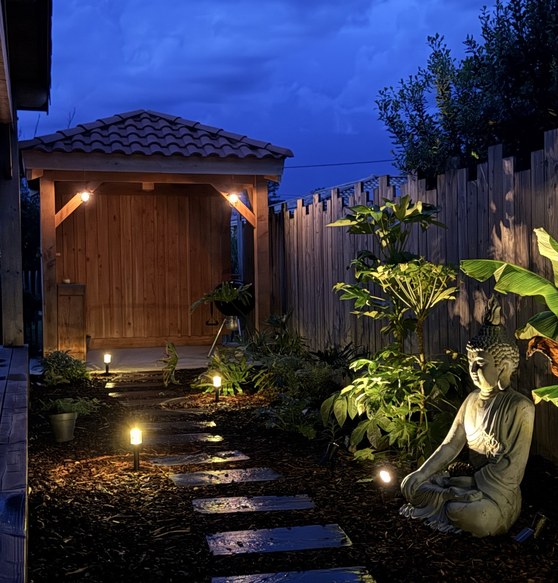 Allée de jardin paysagée et éclairée de nuit